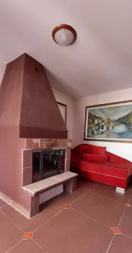 A room with a large fireplace and a red sofa. - image 6