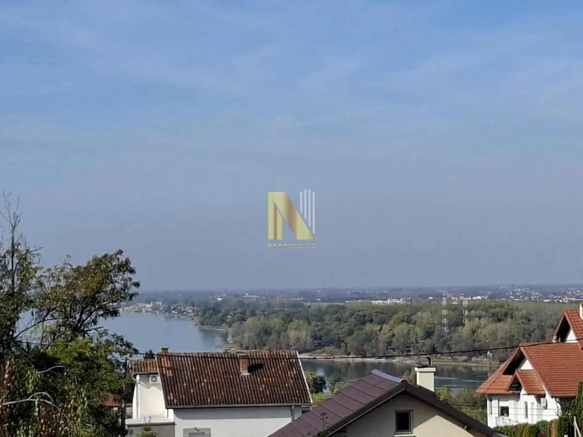 Pogled sa nekretnine na reku i okolne kuće.