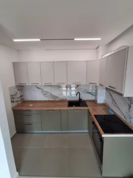 Modern kitchen with light cabinets, wooden countertop and marble-patterned backsplash. - image 14