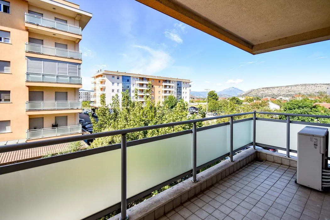 View from the balcony overlooking surrounding buildings and landscape.