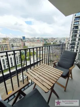 Namešten balkon sa stolom, stolicama i pogledom na grad. - image 11