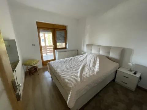 Nameštena spavaća soba sa bračnim krevetom, noćnim stočićem i izlazom na terasu. - image 44