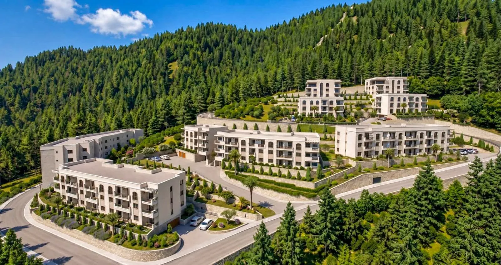 Pogled iz ptičje perspektive na stambeni kompleks okružen šumom.