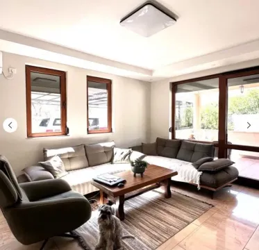 Living room with a sofa, armchair, coffee table, and terrace access. - image 7