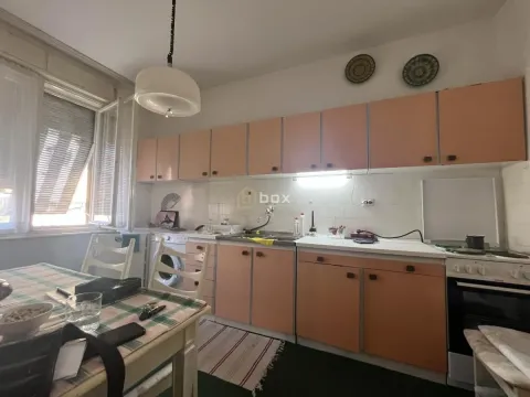 Starija kuhinja sa svetlim elementima i trpezarijskim stolom pored prozora. - image 7