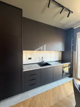Modern dark kitchen with built-in appliances and a sink. - image 5