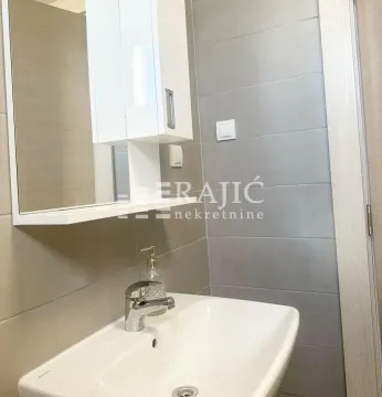 View of a portion of a modern bathroom with a sink and mirror. - image 9