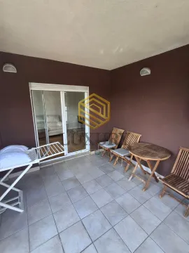 Covered terrace with a wooden table, chairs, and a drying rack. - image 7
