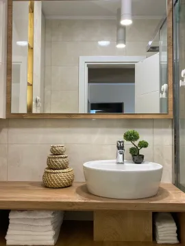 Bathroom detail featuring a basin, large mirror and decorative elements. - image 18