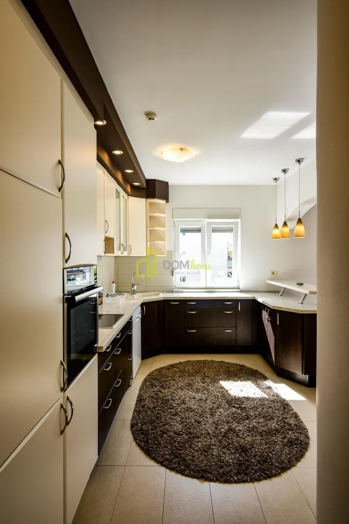 Equipped kitchen with dark and white cabinets and a window.