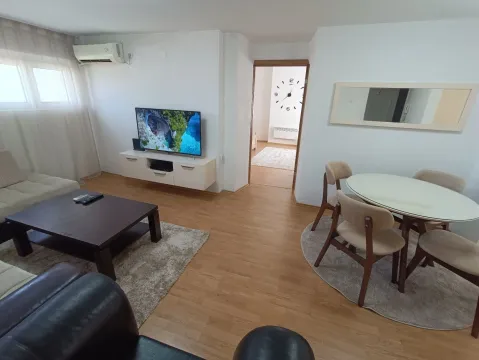 Living room with a sofa set, television, and a dining table with chairs. - image 7
