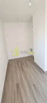Prazna prostorija sa bijelim zidovima i laminatom na podu. - image 5