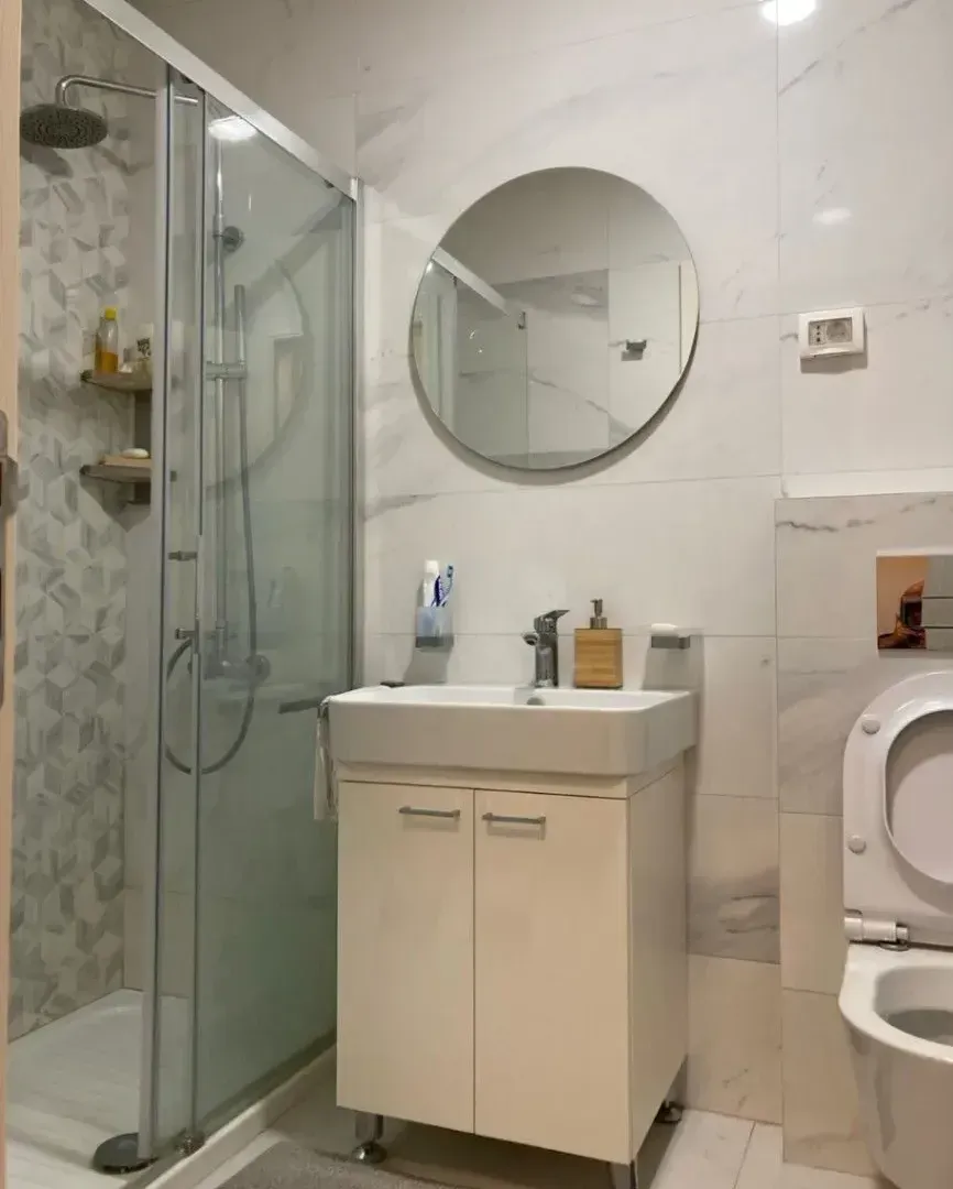 Savremeno opremljeno kupatilo sa tuš kabinom, umivaonikom i wc šoljom.