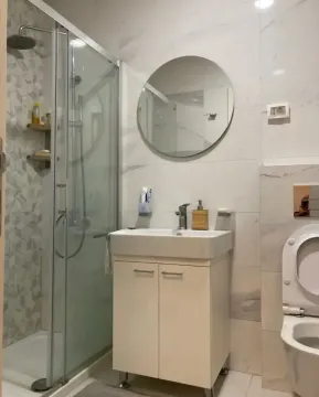 Savremeno opremljeno kupatilo sa tuš kabinom, umivaonikom i wc šoljom. - image 5