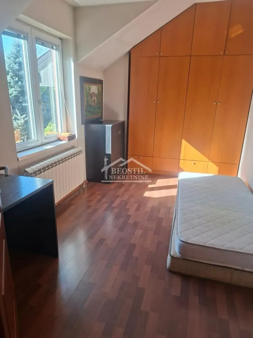 Smaller bedroom with a bed, desk, and built-in wardrobe.