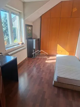 Smaller bedroom with a bed, desk, and built-in wardrobe. - image 10