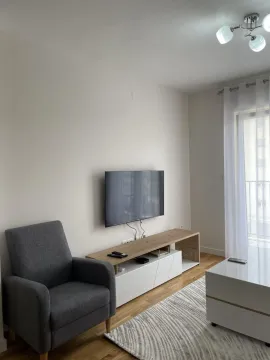 Living room with an armchair, TV and white TV unit. - image 4