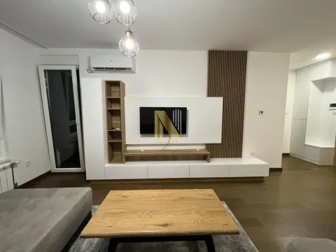 Dnevna soba sa TV elementom, kaučem i drvenim stočićem. - image 3