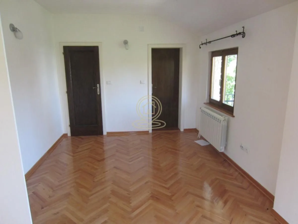 Empty room with parquet flooring and two doors.