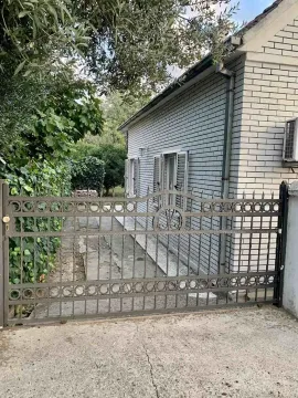 A metal yard gate in front of a house with a grey facade. - image 5
