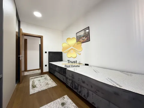 Manja spavaća soba sa dva kreveta i drvenim podom. - image 11