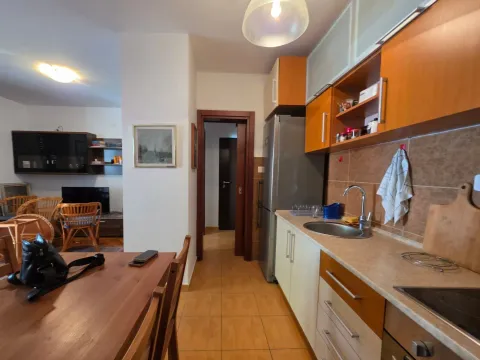 Kuhinja opremljena drvenim elementima sa trpezarijskim stolom u prvom planu. - image 12