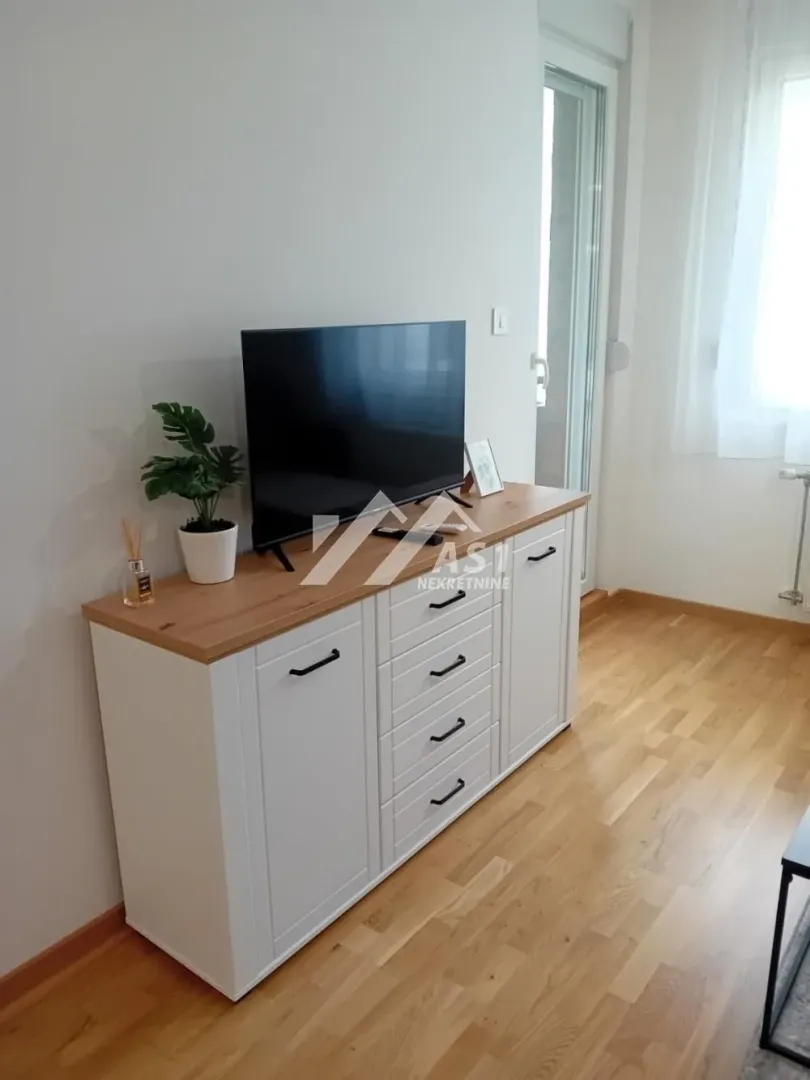 Komoda sa televizorom i dekoracijom u dnevnoj sobi.