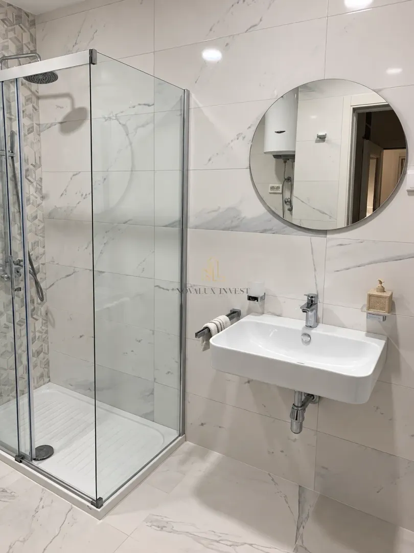 Modernly equipped bathroom with a shower cabin and washbasin.