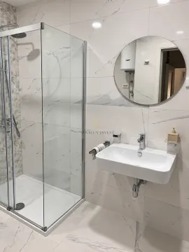 Modernly equipped bathroom with a shower cabin and washbasin. - image 7