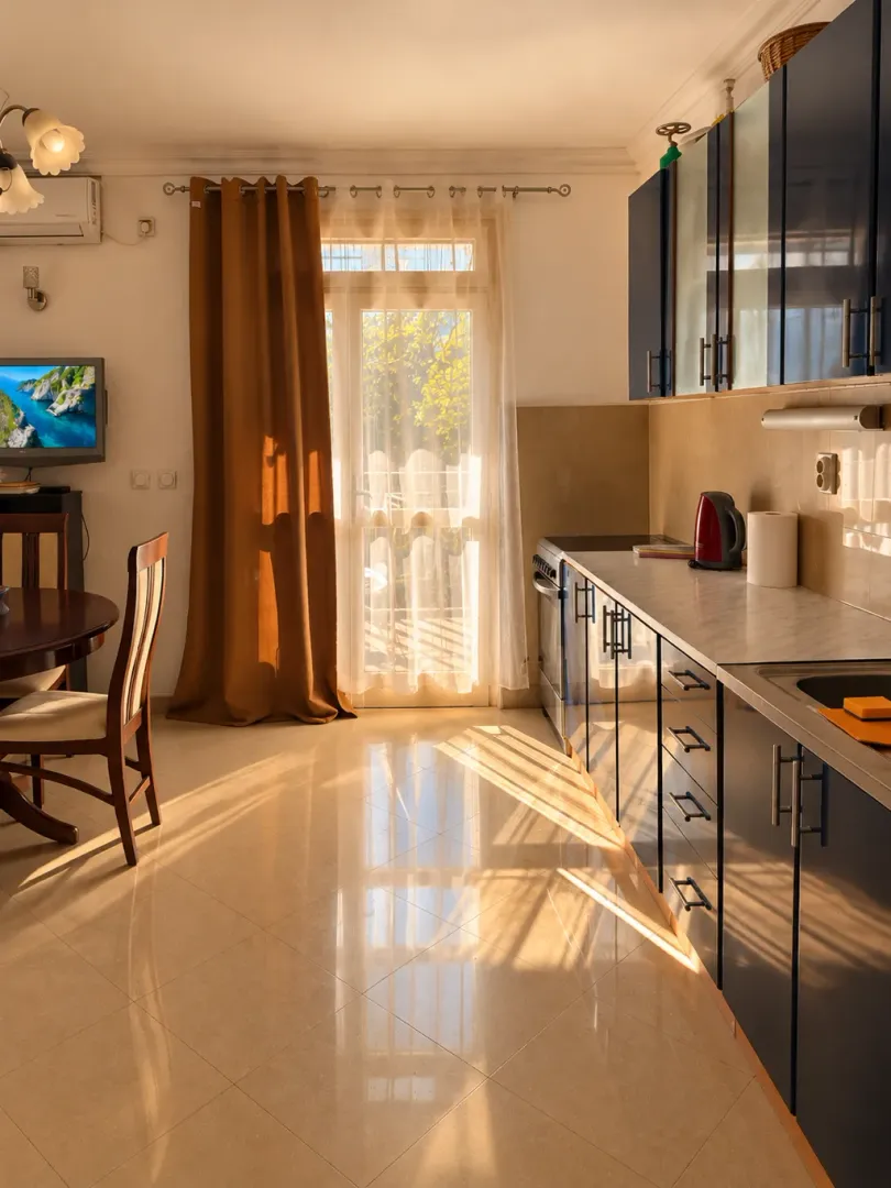 Modern kitchen with dark cabinets and a dining area next to the balcony door.