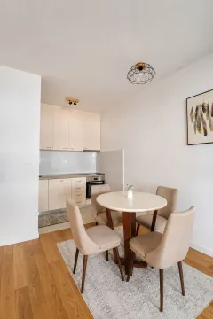 Dining area with a table and chairs and a view of the kitchen. - image 4