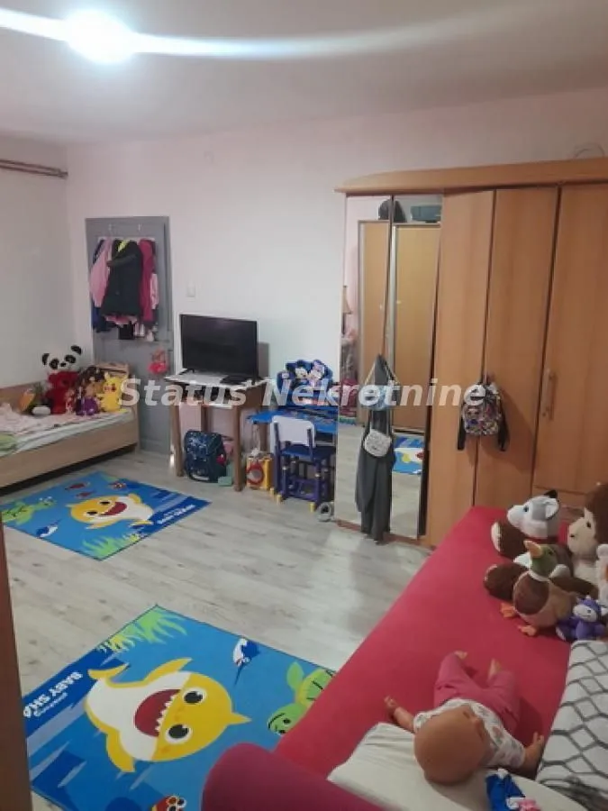 Dečja soba sa krevetom, ormanom i igračkama.