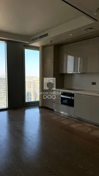 Modern kitchen with fitted units and a large window offering city views. - image 5