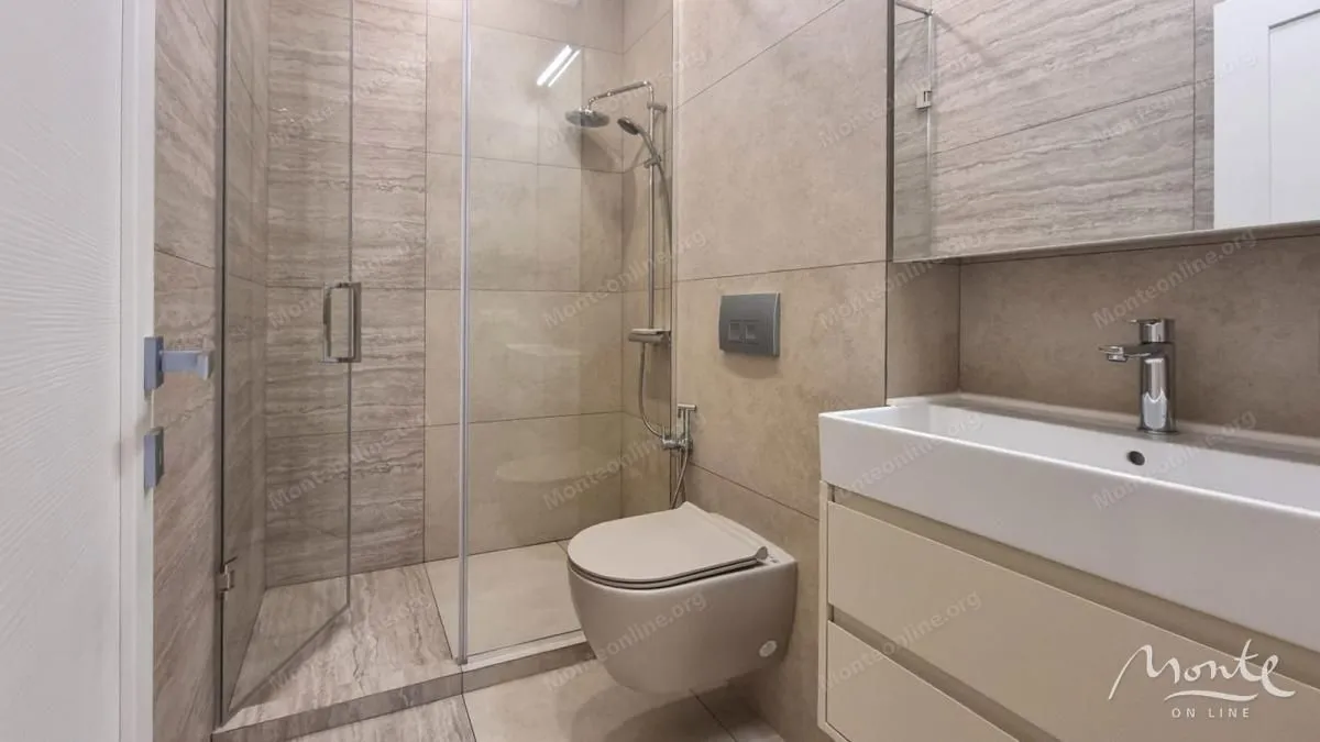 Moderne kupatilo sa tuš kabinom, umivaonikom i wc šoljom.