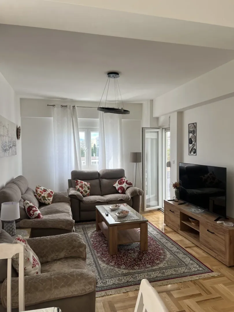 Bright living room with comfortable seating and a television.