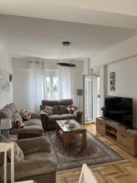 Bright living room with comfortable seating and a television. - image 2