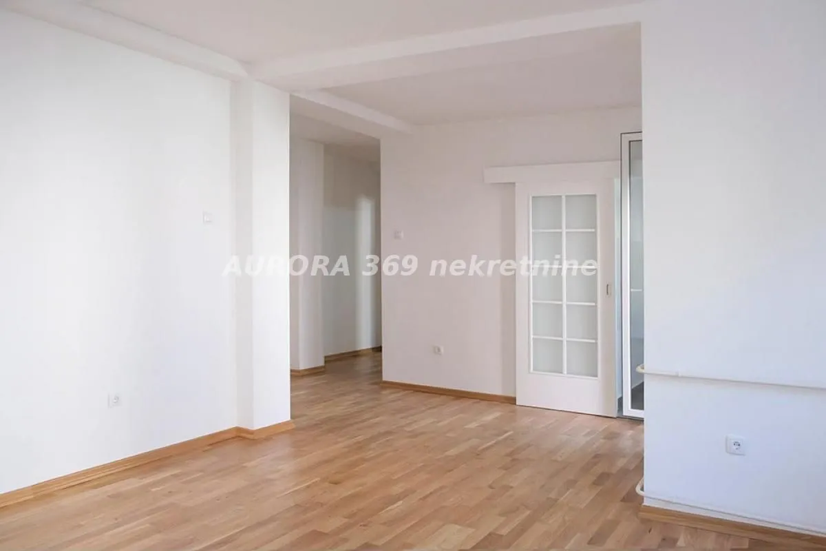 Empty bright room with parquet flooring and white walls.