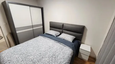 Furnished bedroom with a double bed, wardrobe, and bedside table. - image 5