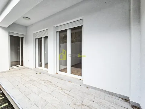 Prostrana popločana terasa sa balkonskim vratima i roletnama. - image 7