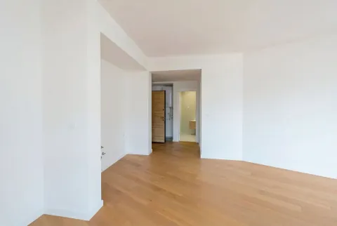 Prazna, svijetla prostorija sa modernim parketom i bijelim zidovima. - image 3