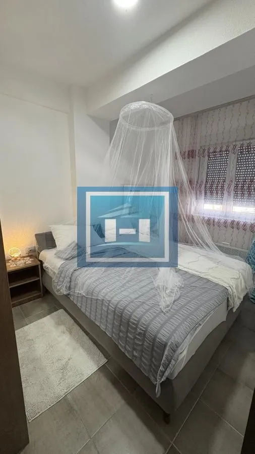 Bedroom with a double bed, bedside table, and a canopy above the bed.