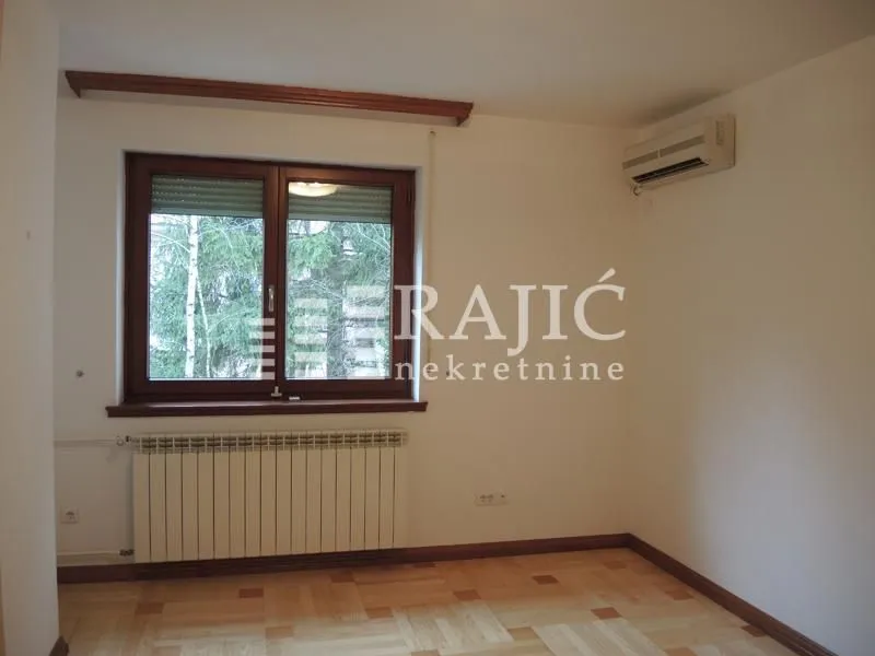 Empty room with a window, parquet flooring, and an air conditioner.