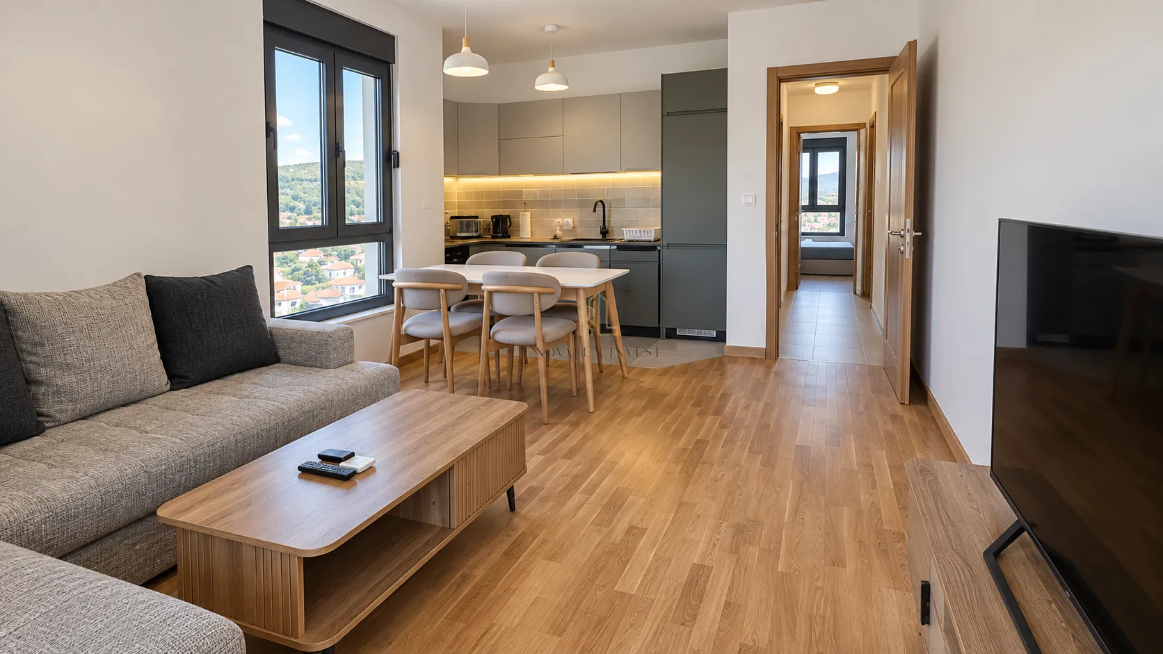 Living room with a sofa and dining area connected to the kitchen.