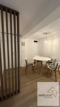 Trpezarija sa okruglim stolom, četiri stolice i drvenom pregradnom pregradom u enterijeru. - image 7