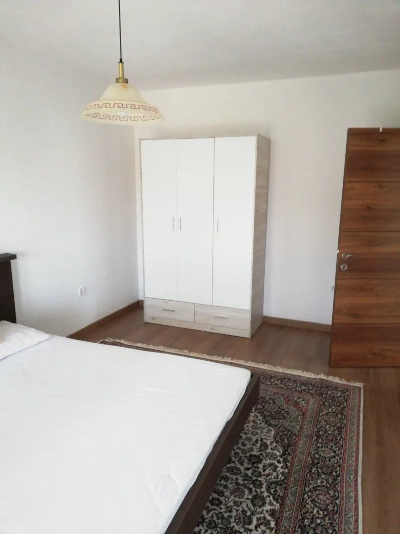 Simply furnished bedroom with a bed and a wardrobe.