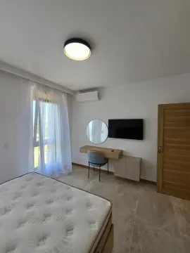 Bedroom with a bed, desk, mirror, and wall-mounted television. - image 6