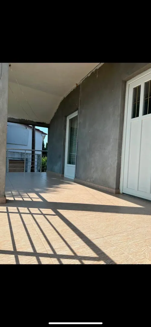 Covered terrace with tiled flooring and an entrance door.