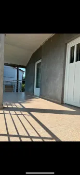 Covered terrace with tiled flooring and an entrance door. - image 3