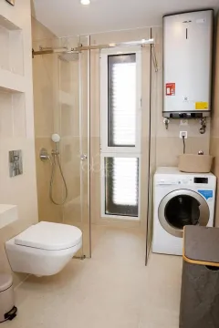 Kupatilo opremljeno tuš kabinom, konzolnom šoljom, veš mašinom i bojlerom. - image 10