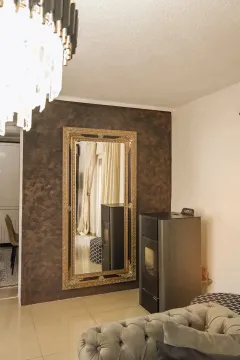 Living room with sofa, pellet stove, and a large wall mirror. - image 8
